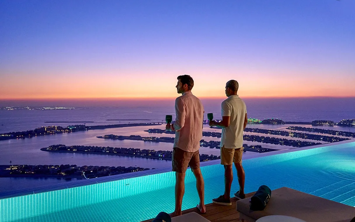 Sunset view from the pool deck with guests enjoying cocktails