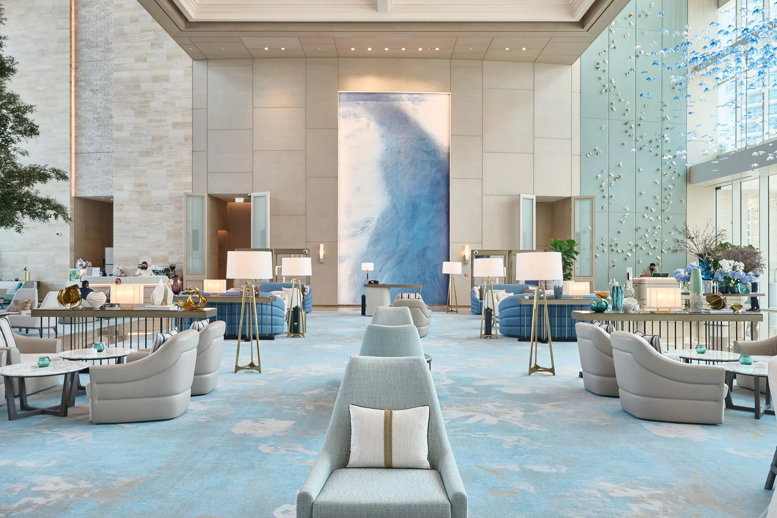 Elegant entrance to the pool area with concierge staff and stylish lounge chairs