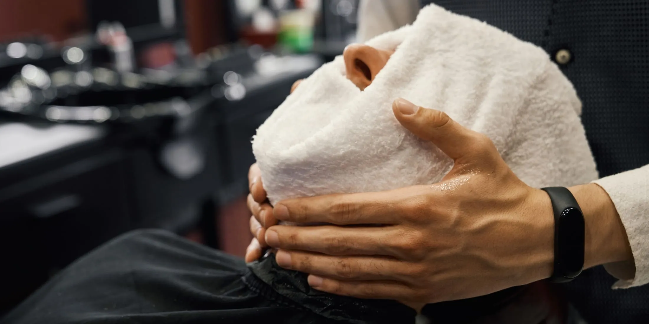 Client receiving a hot towel treatment and straight razor shave